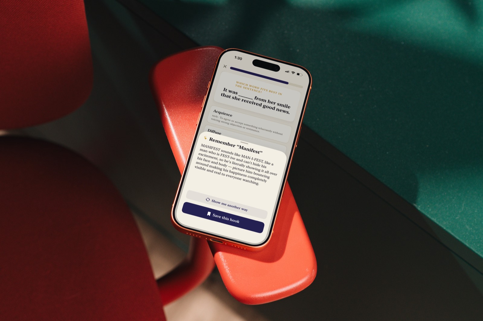 An iPhone resting on a red chair, showing the memory hook for Manifest with Show me another way and Save this hook buttons