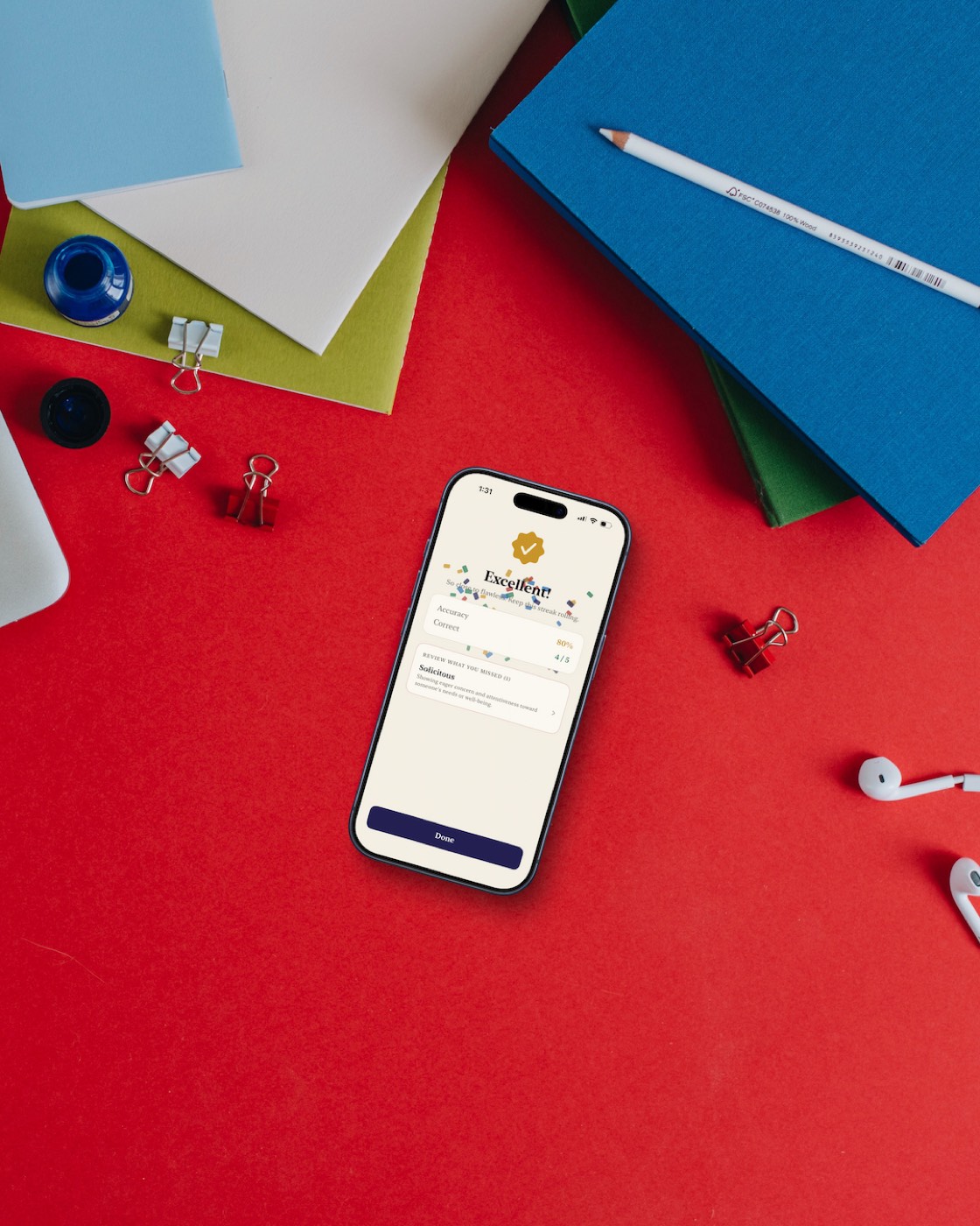 An iPhone among notebooks on a red desk, showing a lesson results screen: Excellent, 80% accuracy, one missed word to review